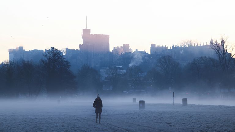 Windsor Castle is seen as a person walks through mist and frost before sunrise in Windsor, Britain, January 13, 2022. REUTERS/Henry Nicholls 