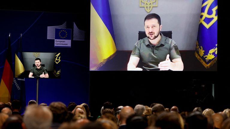 Attendees watch Ukrainian President Volodymyr Zelenskyy&#39;s   keynote address on a screen during a conference on post-war reconstruction of Ukraine in Berlin, Germany