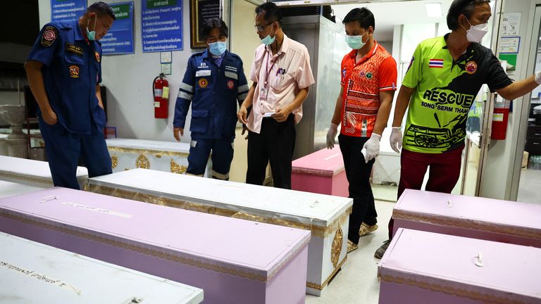 Rescue workers stand next to coffins containing the bodies of victims at Udon Thani hospital in Udon Thani province, following a mass shooting in the town of Uthai Sawan, around 500 km northeast of Bangkok in the province of Nong Bua Lam Phu, Thailand October 7, 2022. REUTERS/Athit Perawongmetha