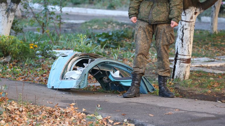 A soldier stands next to wreckage at the scene of a crashed warplane in a residential area in Yeysk, Russia, Tuesday, Oct. 18, 2022. A Russian warplane crashed into the area in a Russian city on the Sea of Azov after suffering engine failure, leaving a number dead and injured. (AP Photo)