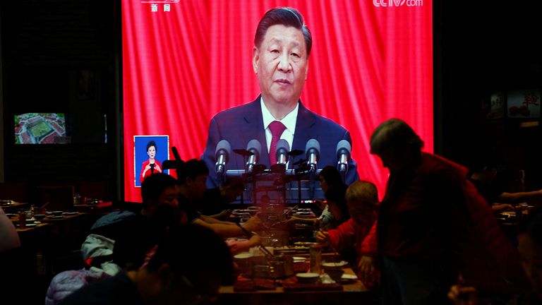 I commensali mangiano davanti a uno schermo che mostra una trasmissione in diretta del discorso del presidente cinese Xi Jinping alla cerimonia di apertura del 20° Congresso Nazionale del Partito Comunista Cinese, all'interno di un ristorante a Pechino, Cina, 16 ottobre 2022. REUTERS/Tingshu Wang