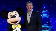 Disney Chairman and CEO Bob Iger, right, poses with an entertainer dressed in a costume of Micky Mouse. Pic: AP