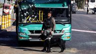 A police officer holds a service dog near a damaged bus after two explosions in Jerusalem November 23, 2022. REUTERS/Ronen Zvulun