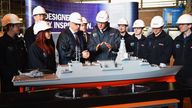 Then prime minister David Cameron (C) looks at a model of The Type-26 Global Combat Ship (GCS) as he visits the BAE Systems shipyard in Govan, Scotland, in 2015