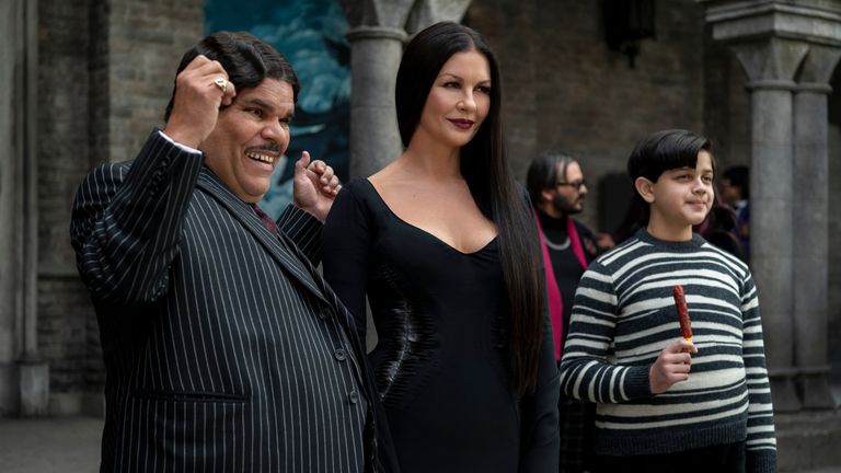 Luiz Guzmán, Catherine Zeta-Jones, and Issac Ordonez star as other members of The Addams Family - Gomez, Morticia, and Pugsley (L to R). Credit: Courtesy of Netflix