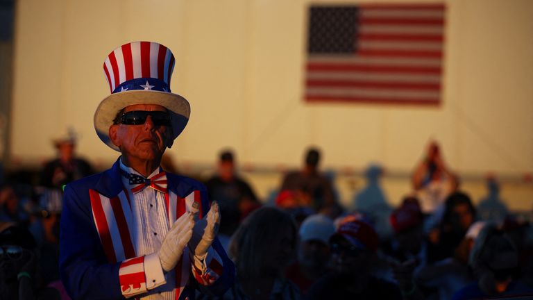A man wearing an Uncle Sam costume applauds during a rally for former U.S. President Donald Trump ahead of the midterm elections in Mesa, Arizona, U.S., October 9, 2022.  REUTERS/Brian Snyder
