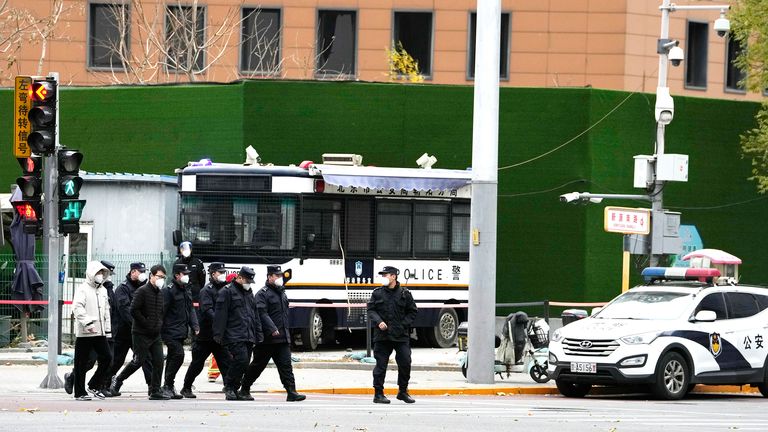 Chinese security personnel walk past a junction near the site of protest the day before in Beijing 