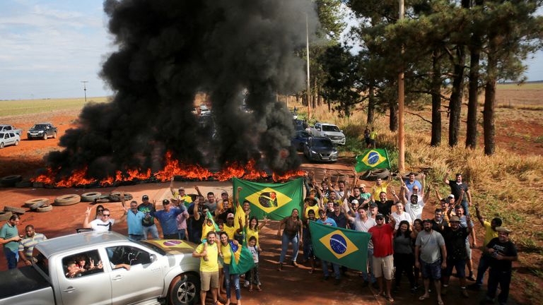 Сторонники президента Бразилии Жаира Болсонару блокируют автомагистраль BR-251 во время акции протеста против избранного президента Луиса Инасиу Лулы да Силвы, переизбранного на третий срок после второго тура президентских выборов, в Планалтине, Бразилия, 31 октября 2022 года. день (Рейтер)