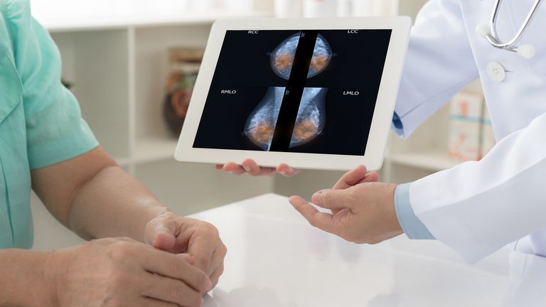 breast cancer concept. doctor explain mammogram results of breast test from x-ray scan on digital tablet screen to patient.