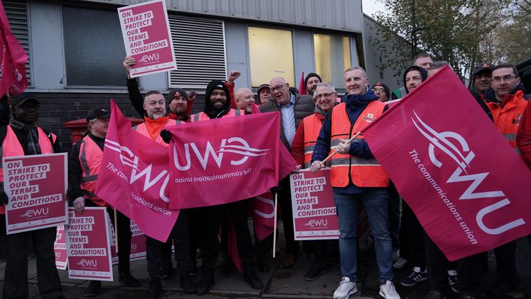 Communication Workers Union (CWU) general secretary Dave Ward (centre) joins postal workers on the picket line at the Camden Town Delivery Office in north west London