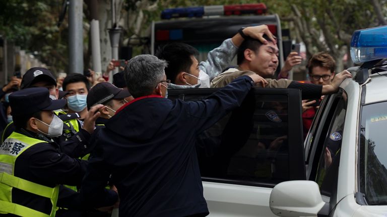 In this photo taken on Sunday, Nov. 27, 2022, a protester is forced into a police car by the police, during a protest on a street in Shanghai, China. 
PIC:AP