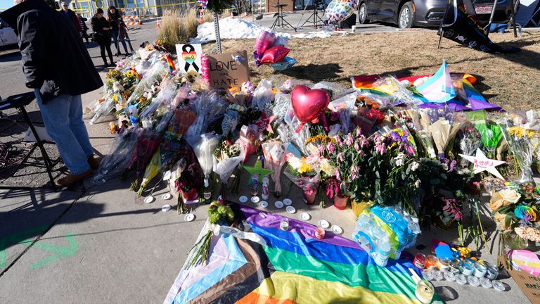Bouquets of flowers stand on a corner near the site of a mass shooting at a gay bar on Monday, November 21, 2022 in Colorado Springs, Colo.  The man suspected of killing five people and injuring others at a Colorado Springs gay bar has faced murder and hate crime charges, according to online court records obtained Monday.  (AP Photo/David Zalubowski)