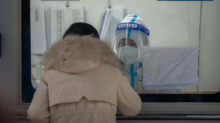 A worker wearing a protective suit administers a COVID-19 test to a woman at a coronavirus testing site in Beijing, Friday, Nov. 18, 2022. Chinese authorities faced more public anger Thursday after a second child&#39;s death was blamed on overzealous anti-virus enforcement, adding to frustration at controls that are confining millions of people to their homes and sparked fights with health workers. (AP Photo/Mark Schiefelbein)