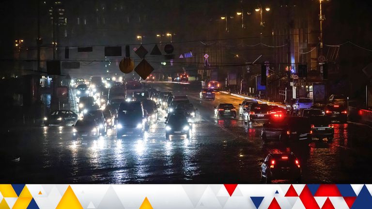 Cars drive down a street without electricity in central Kyiv. Electricity saving mode has been introduced throughout Ukraine after Russia&#39;s attacks on Ukraine&#39;s energy infrastructure.

