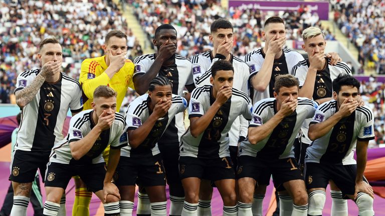 German football players close their mouths while taking a picture with the team before the match 