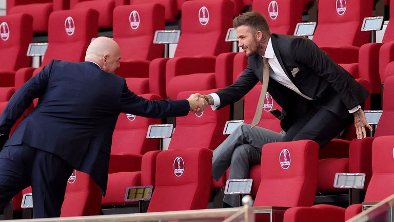 FIFA president Gianni Infantino shakes hands with David Beckham in the stands before the match