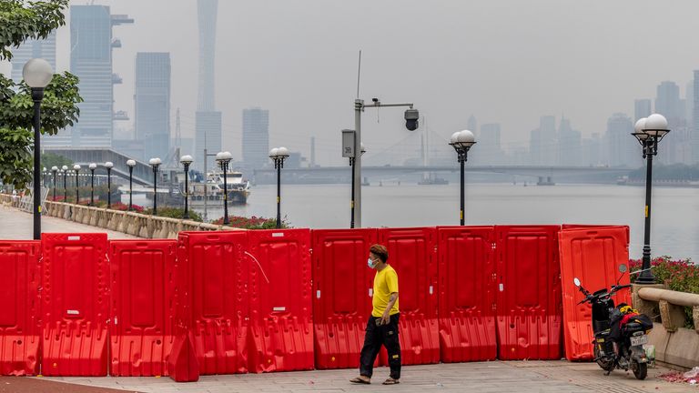 A deliveryman outside a Covid-19 lockdown zone waits for his customer to pick up the delivery in Guangzhou in south China&#39;s Guangdong province Thursday, Nov. 17, 2022.  (FeatureChina via AP Images)