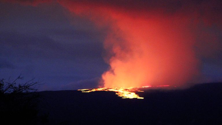 Lava pours out of the summit crater of Mauna Loa about 6:35 a.m. Monday, Nov. 28, 2022, as seen from Gilbert Kahele Recreation Area on Maunakea, Hawaii. Mauna Loa, the world...s largest active volcano,  began spewing ash and debris from its summit, prompting civil defense officials to warn residents on Monday to prepare in case the eruption causes lava to flow toward communities. (Chelsea Jensen/West Hawaii Today via AP)