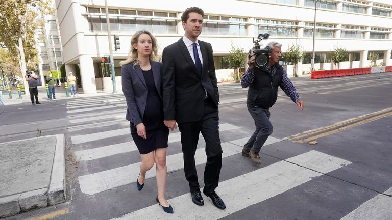 Former Theranos CEO Elizabeth Holmes, left, walks with her partner, Billy Evans, after leaving federal court in San Jose, Calif., on Monday, Oct. 10.  17th, 2022.  (AP Photo/Jeff Chiu)