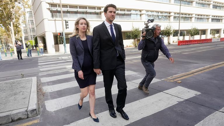 Former Theranos CEO Elizabeth Holmes, left, walks with her partner, Billy Evans, after leaving federal court in San Jose, Calif., Monday, Oct. 17, 2022. (AP Photo/Jeff Chiu)