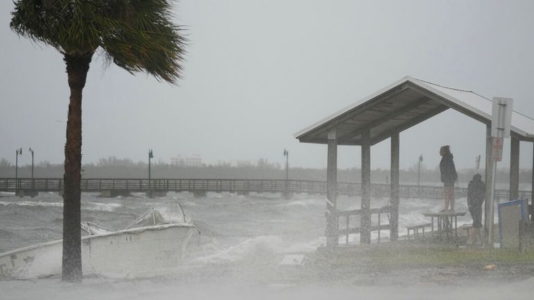 People in Jensen Beach brave rain and heavy wind as the hurricane approaches. Pic: AP