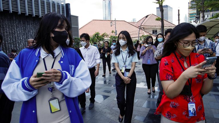 People gather as they are evacuated outside a building following an earthquake in Jakarta, Indonesia, November 21, 2022. REUTERS/Ajeng Dinar Ulfiana