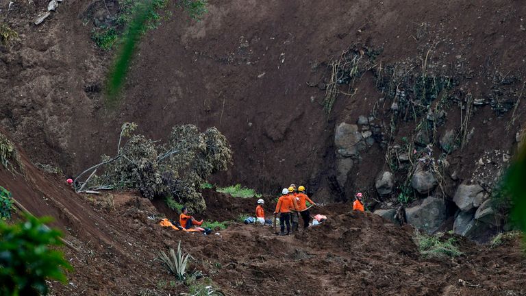 Rescue workers search for victims at the site where an earthquake-triggered landslide struck in Cianjur, West Java, Indonesia, Friday, Nov. 25, 2022. Monday's earthquake killed hundreds of people, many of them children, and injured thousands of people.  (AP Photo/Achmad Ibrahim)