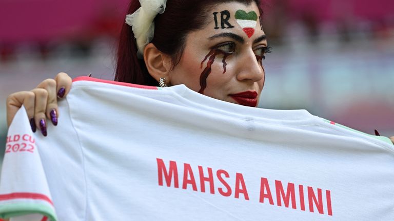 An Iran fan is holds a t-shirt in memory of Mahsa Amini, inside the  Ahmad bin Ali Stadium in Al Rayman, Qatar, before the match against Wales
