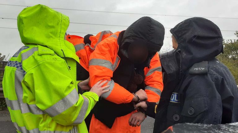 A Just Stop Oil protester is detained by officers on the M25. Pic: Essex Police 
