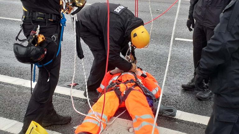 A Just Stop Oil protester is removed from an overhead motorway gantry by officers on the M25. Pic: Essex Police 