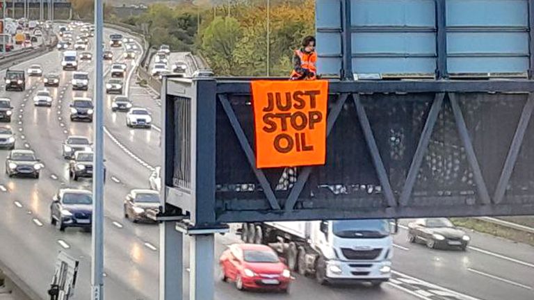 Handout photo issued by Just Stop Oil of an activist on a overhead gantry on the M25. Just Stop Oil said around 10 of its supporters climbed onto overhead gantries in "multiple locations" on the M25 from 6.30am on Wednesday, in what is the third consecutive day of protests on the UK&#39;s busiest motorway. Issue date: Wednesday November 9, 2022.