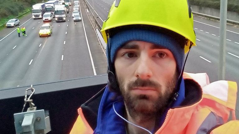 A Just Stop Oil activist on an overhead gantry on the M25 