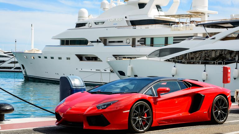 A Lamborghini parked in front of luxury yachts on the Costa del Sol in Marbella, Spain