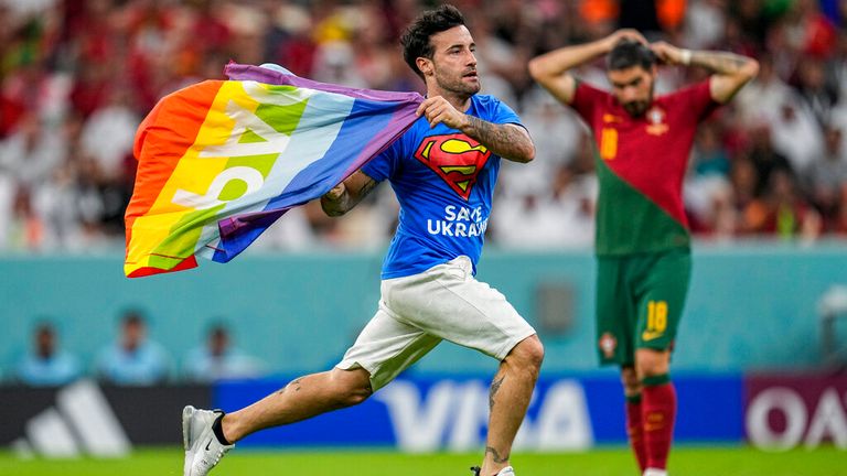 Un invasor del estadio corre por el campo con una bandera del arcoíris durante el partido de fútbol del Grupo H de la Copa Mundial entre Portugal y Uruguay, en el Estadio Lusail en Lusail, Qatar, el lunes 28 de noviembre de 2022. (Foto AP/Abbie Parr)