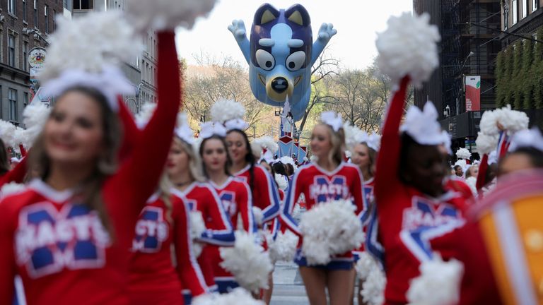 Spirit of America Cheerleaders at the 96th Annual Macy's Thanksgiving Day Parade in Manhattan, New York City with blue balloons flying 