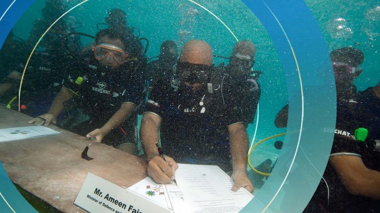 Maldivian Minister of Defense and National Security Ameen Faisal, center, signs a document calling on all countries to cut down their carbon dioxide emissions ahead of a major U.N. climate change conference in December in Copenhagen, in Girifushi, Maldives, Saturday, Oct. 17, 2009. Government ministers in scuba gear held an underwater meeting of the Maldives&#39; Cabinet to highlight the threat global warming poses to the lowest-lying nation on earth. Maldivian President Mohammed Nasheed led Saturda