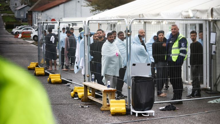 People stand in a fenced off area at the migrant processing center in Manston, Britain November 7, 2022. REUTERS/Henry Nicholls