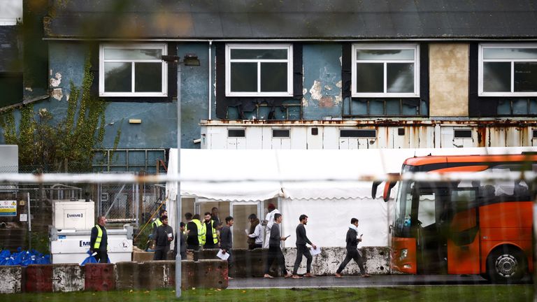 People board a bus inside the migrant processing centre, during the visit of British Home Secretary Suella Braverman, in Manston Britain, November 3, 2022. REUTERS/Henry Nicholls /Handout via REUTERS THIS IMAGE HAS BEEN SUPPLIED BY A THIRD PARTY