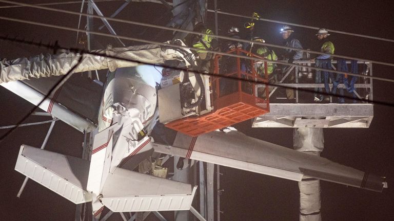 First responders work to rescue aircraft passengers after the small plane crashed and became stuck in live power lines, Monday, Nov. 28, 2022, in Montgomery Village, in Maryland