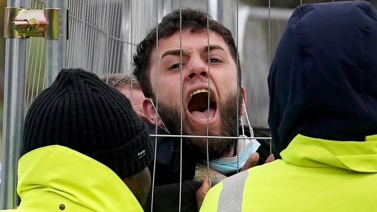 A migrant attempting to communicate with journalists is pinned against a fence by members of staff, before being taken out of view, at the Manston immigration short-term holding facility, located at the former Defence Fire Training and Development Centre in Thanet, Kent. Picture date: Tuesday November 8, 2022. The man claimed he had been at the site for 30 days when staff members asked him to stop shouting, before pinning him against the fence.