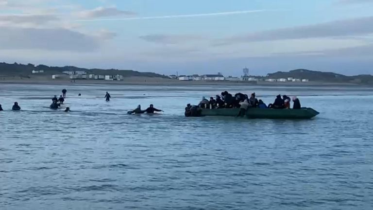 Migrants getting on an inflatable boat in Calais