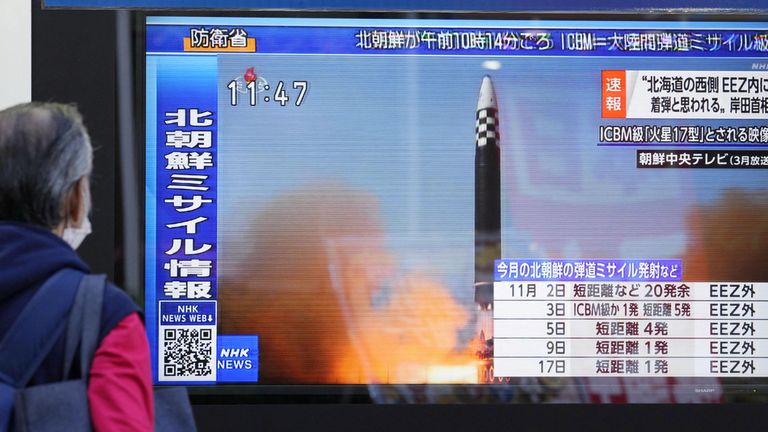 A passerby looks at a television screen showing a news report about North Korea firing a ballistic missile in Tokyo