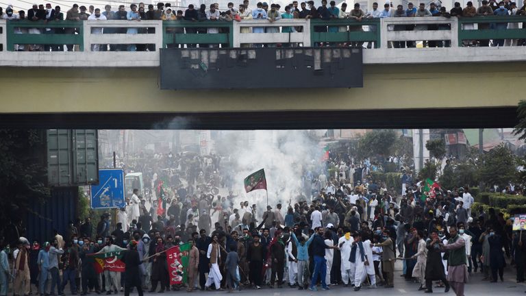 People react as they protest amid tear gas smokes used to disperse them during a protest to condemn the shooting incident on a long march held by Pakistan's former Prime Minister Imran Khan in Wazirabad, in Rawalpindi, Pakistan November 4, 2022. REUTERS/Waseem Khan NO RESALES. NO ARCHIVES.
