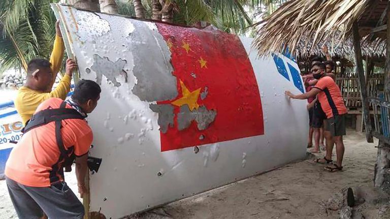 In this handout photo provided by the Philippine Coast Guard, Coast Guard personnel carry debris, which the Philippine Space Agency said has markings of the Long March 5B (CZ-5B) Chinese rocket that was launched on July 24, after it was found in waters off Mamburao, Occidental Mindoro province, Philippines on Aug. 2022.  In July, the core stage debris of the Long March 5B rocket that was launched in China landed in Philippine waters in an uncontrolled reentry, the agency said. No damage or injuries were reported. (Philippine Coast Guard via AP)