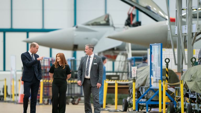 The Prince of Wales talks to BAE Systems apprentice Charlotte and Typhoon delivery director Martin Topping in the BAE Systems Typhoon Maintenance Facility during a visit to RAF Coningsby, Lincolnshire, to learn about future technological innovations and open a new boxing club. Picture date: Friday November 18, 2022.