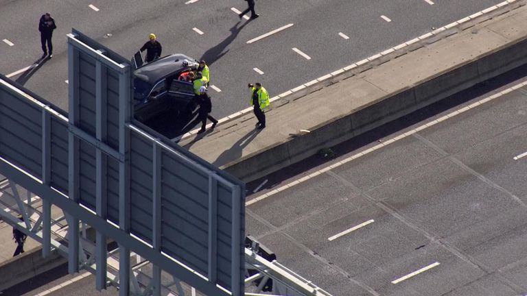 Protester taken into car on M25