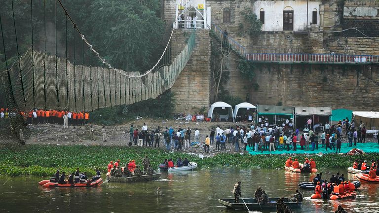 Rescuers sit on boats as Indian Prime Minister Narendra Modi, above, looks at a cable pedestrian bridge that collapsed Sunday in Morbi  
PIC:AP