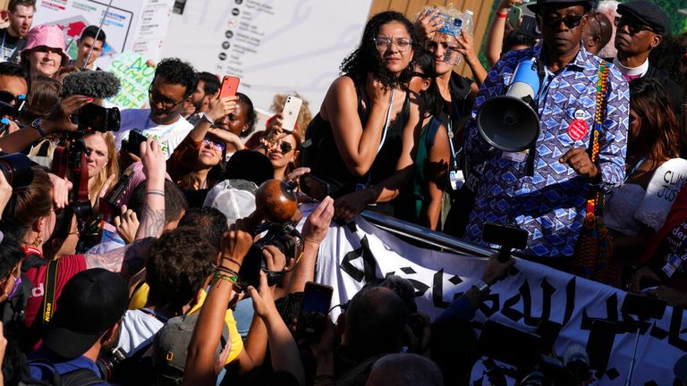 Mısır'ın hapisteki önde gelen demokrasi yanlısı aktivisti Alaa Abdel-Fattah'ın kız kardeşi merkez Sanaa Seif, 12 Kasım 2022 Cumartesi günü Mısır'ın Şarm el-Şeyh kentinde düzenlenen COP27 BM İklim Zirvesi'ndeki bir protestoya katılıyor.  (AP Fotoğrafı/Peter Dejong)