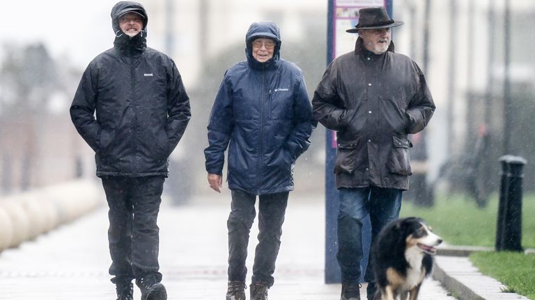 People walk through the rain in Seaham, County Durham. Motorists are being warned to stay off the roads as cars have become stuck in flood water caused by downpours and the UK prepares to suffer "miserable conditions" over the next two days. Picture date: Thursday November 17, 2022.

