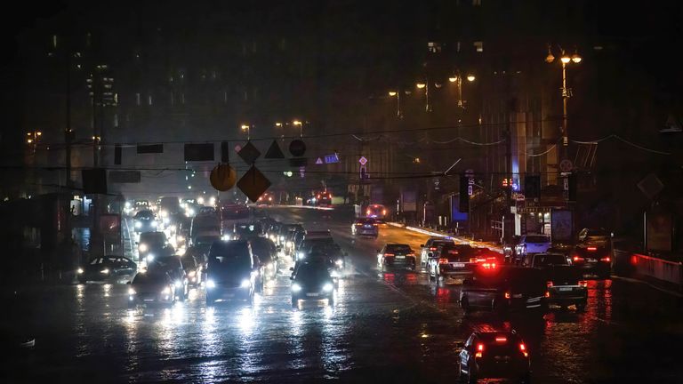 Cars drive down a street without electricity in central Kyiv. Electricity saving mode has been introduced throughout Ukraine after Russia&#39;s attacks on Ukraine&#39;s energy infrastructure.

